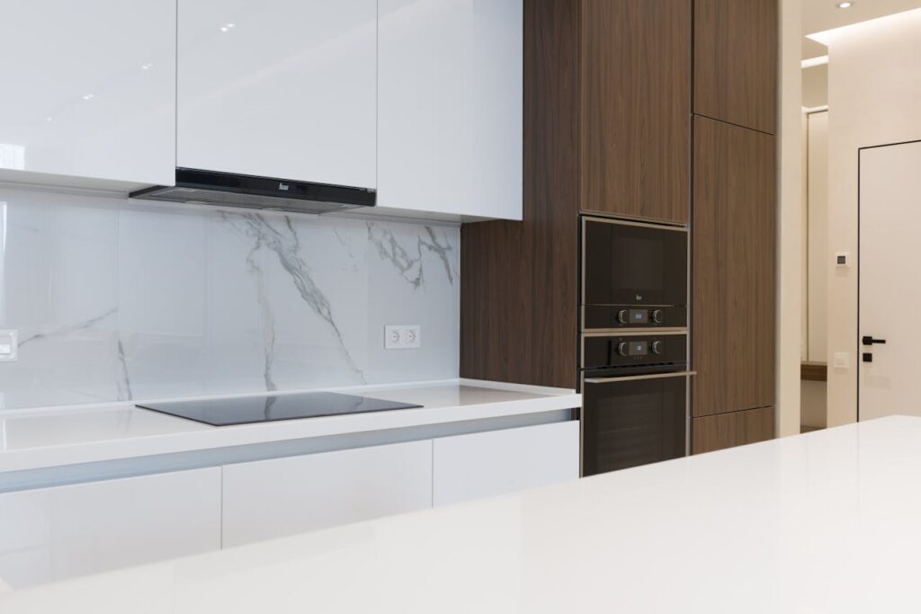 pexels-photo-6636319 Contemporary clean kitchen with sleek appliances and wooden cabinetry, perfect for a new home.