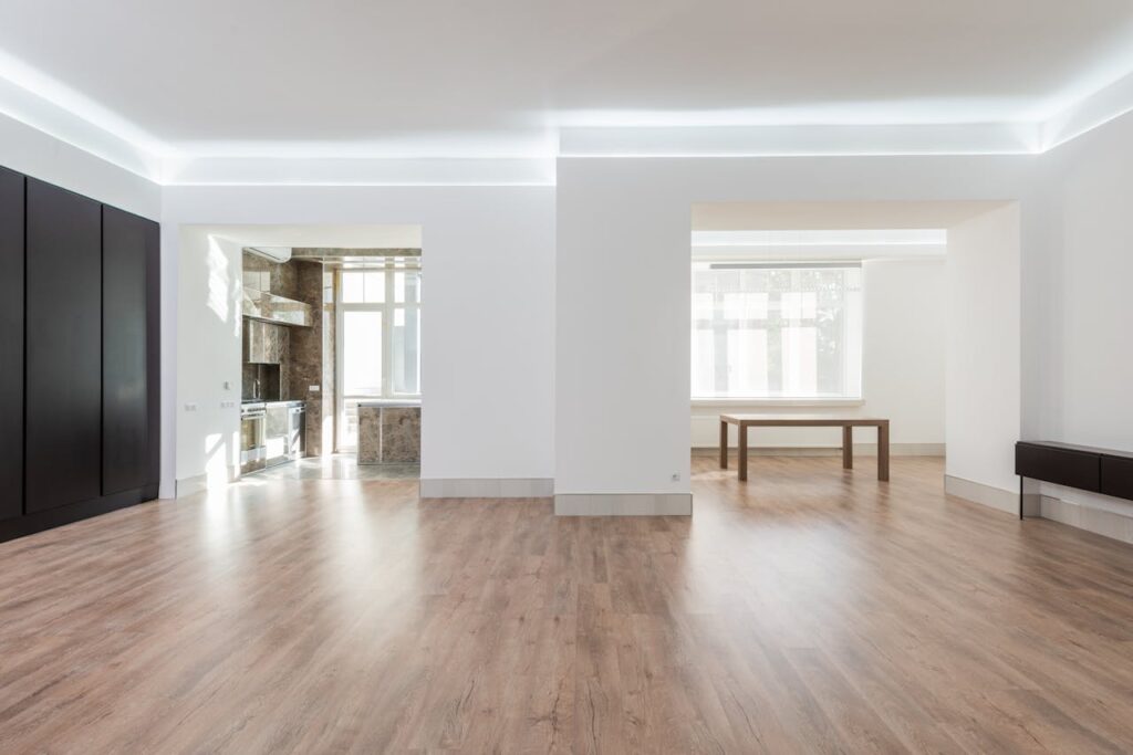 pexels-photo-8146214 Bright and spacious empty room with wooden flooring, modern design, ideal for interior design inspiration.